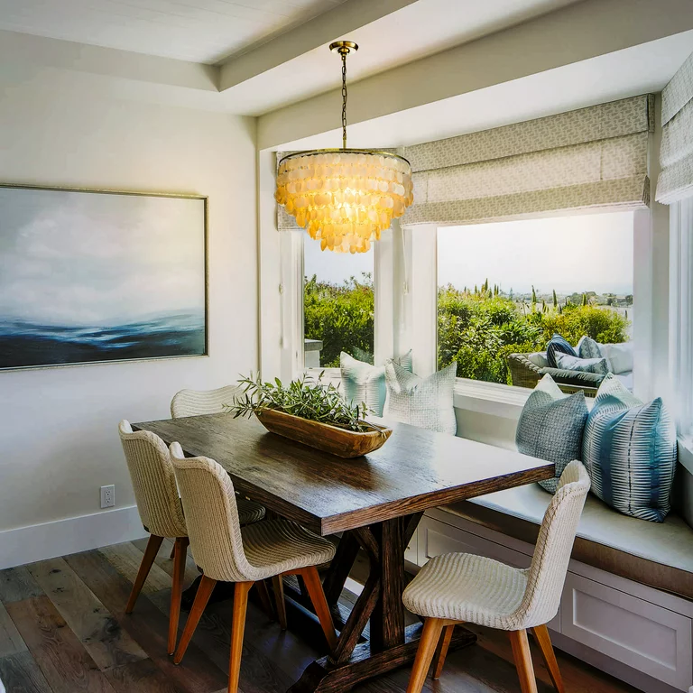 a capiz shell chandelier hanging above wood table