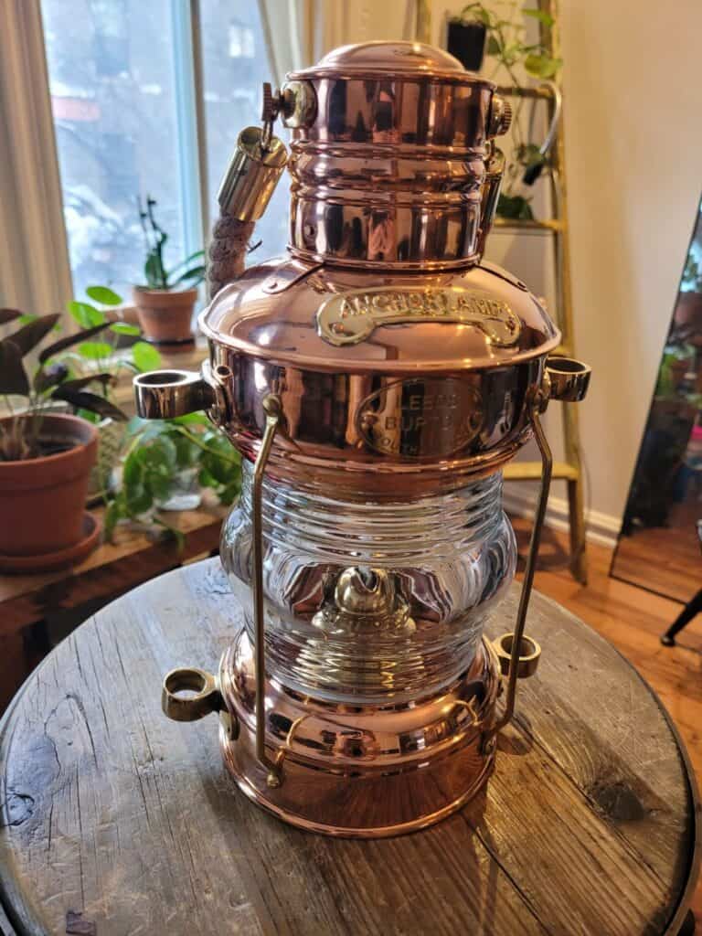 copper lantern sitting on round wood table
