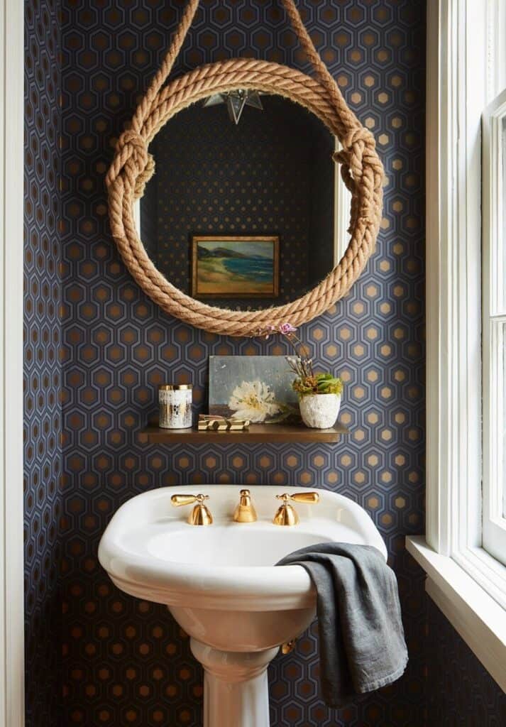 round mirror with thick nautical rope wrapped around edges hanging above bathroom sink
