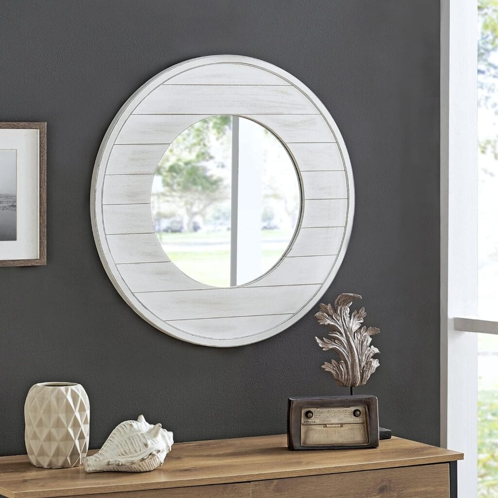 round mirror framed in white shiplap